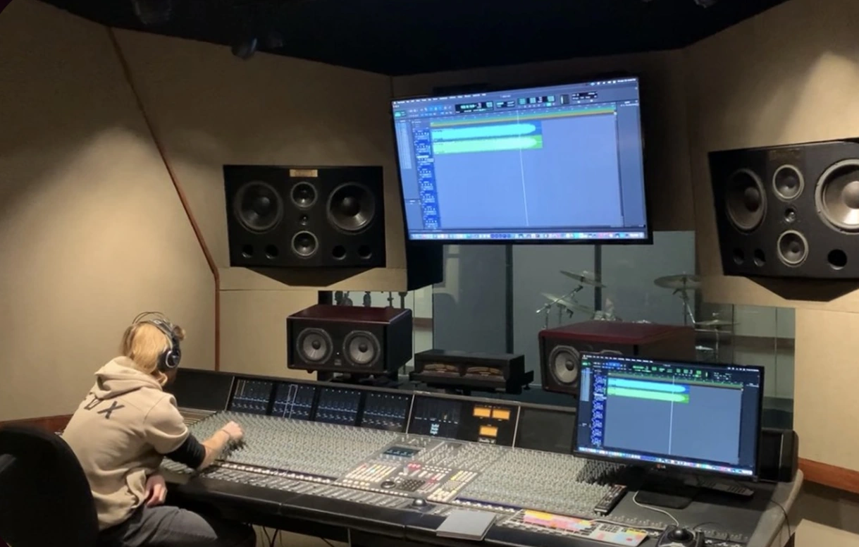A sound design session at a studio mixing desk, surrounded by monitors and speakers